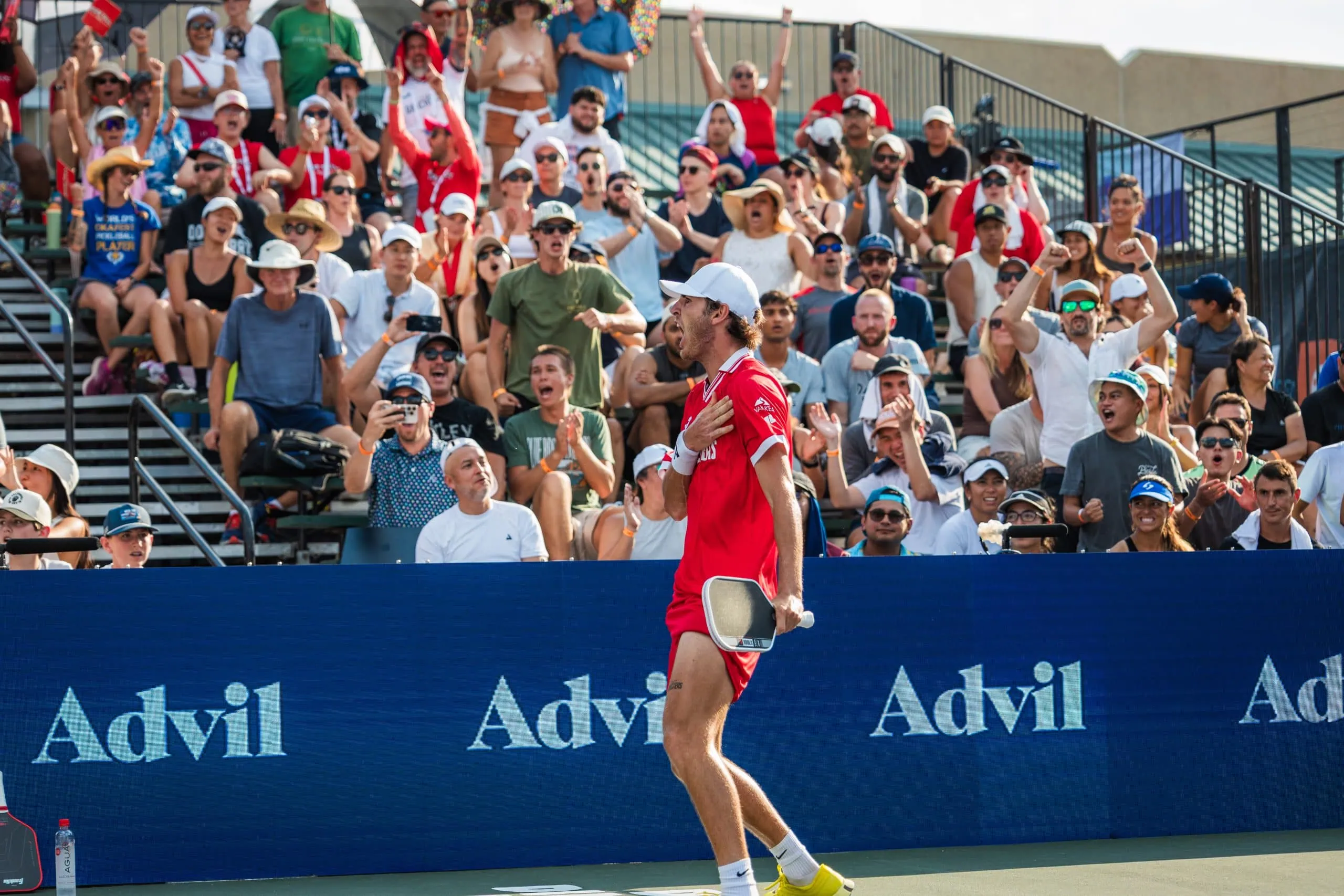 Pickleball player in red celebrating on court during Major League Pickleball match.