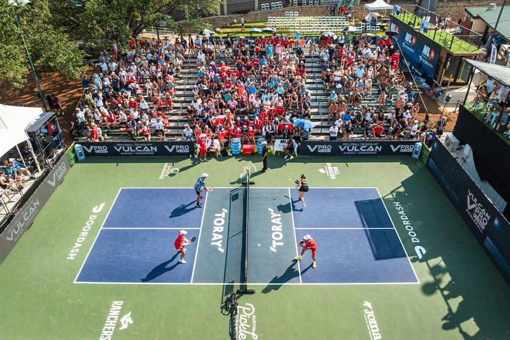Major League Pickleball match with players and crowd at a vibrant outdoor court.