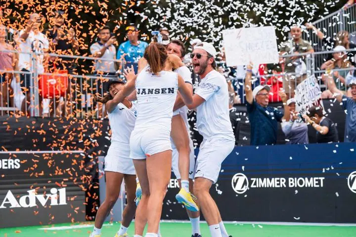 Pickleball players celebrating victory at Major League Pickleball event.