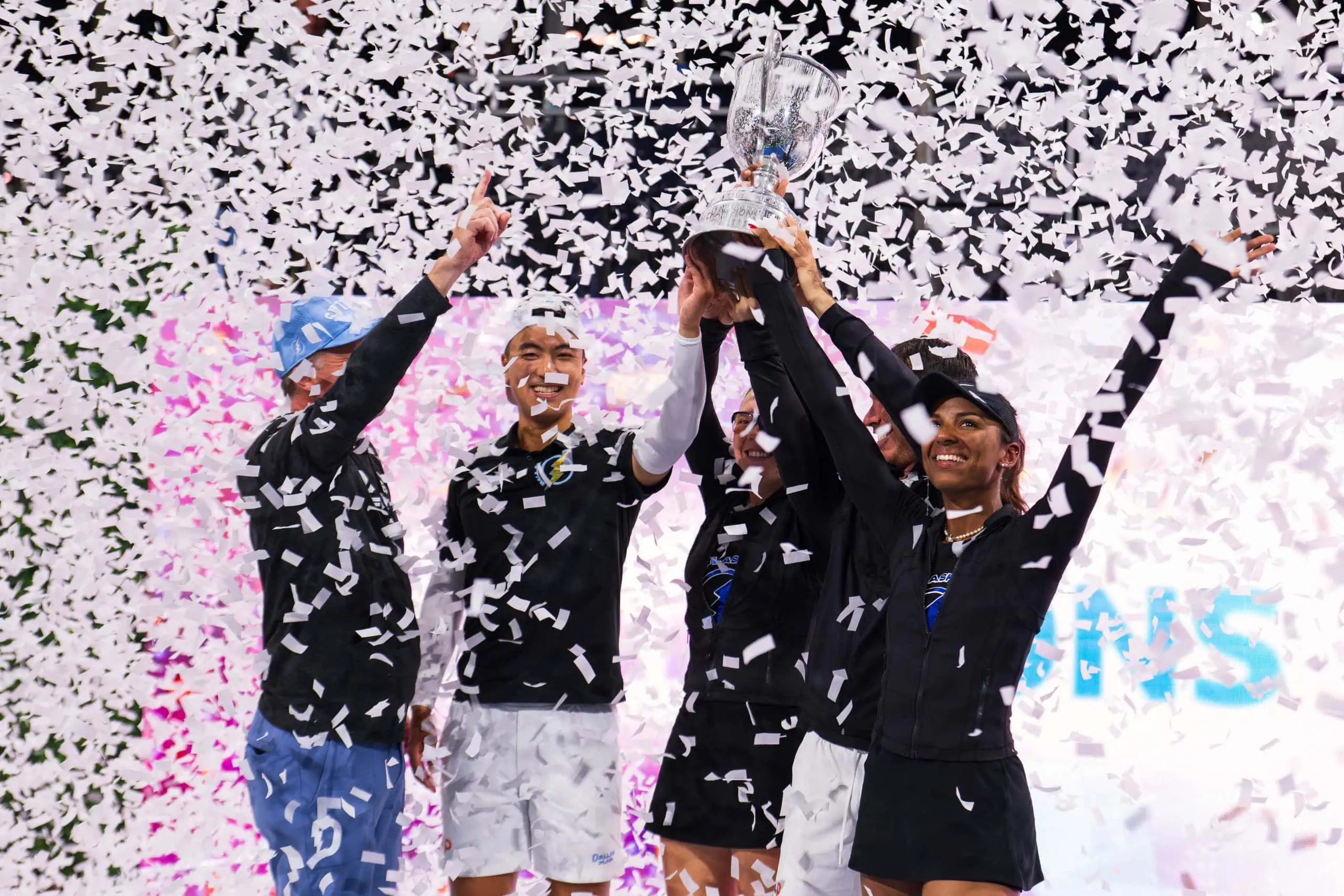 Victory celebration at Major League Pickleball tournament with players holding trophy.