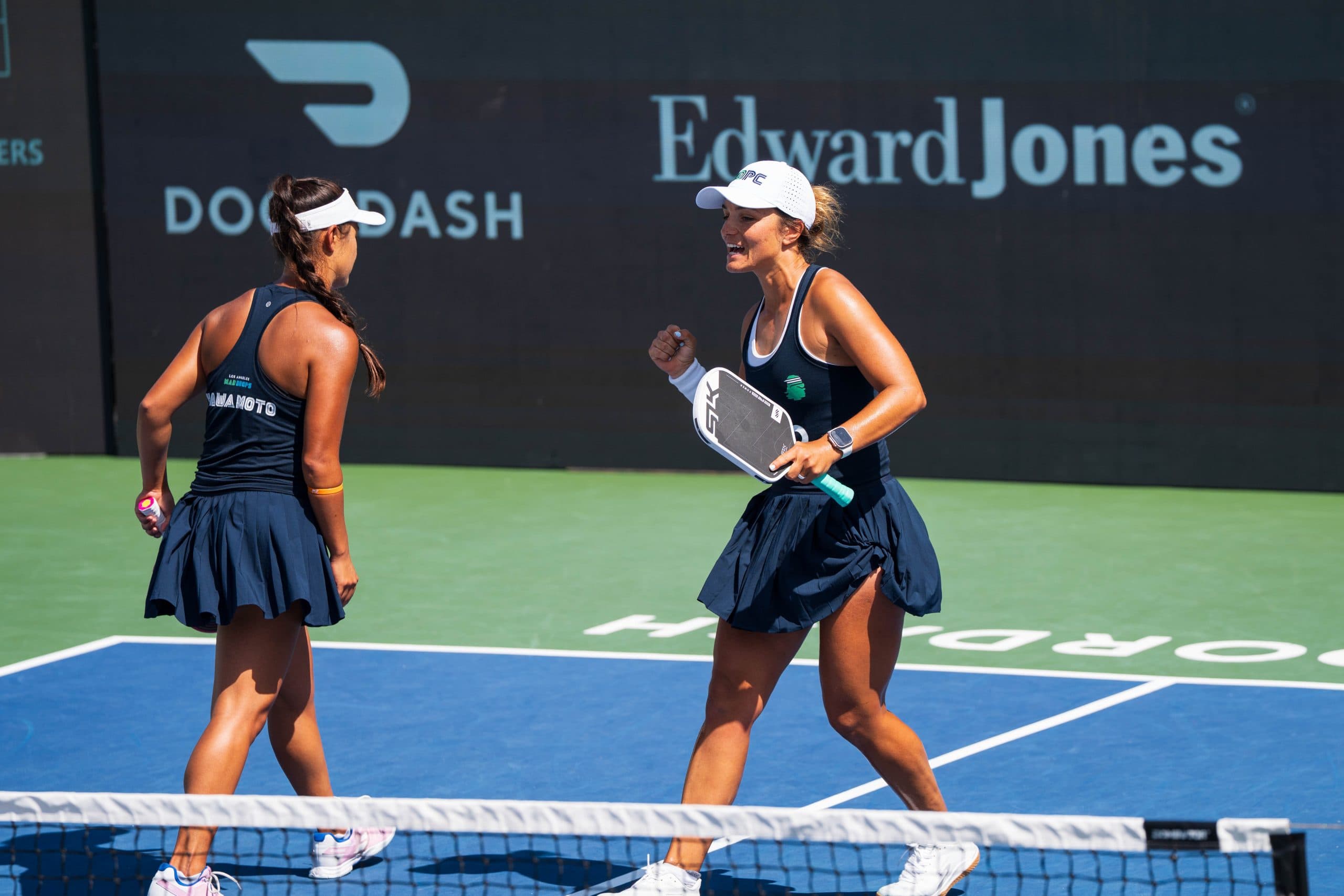 Two female pickleball players celebrating on the court during a Major League Pickleball match.