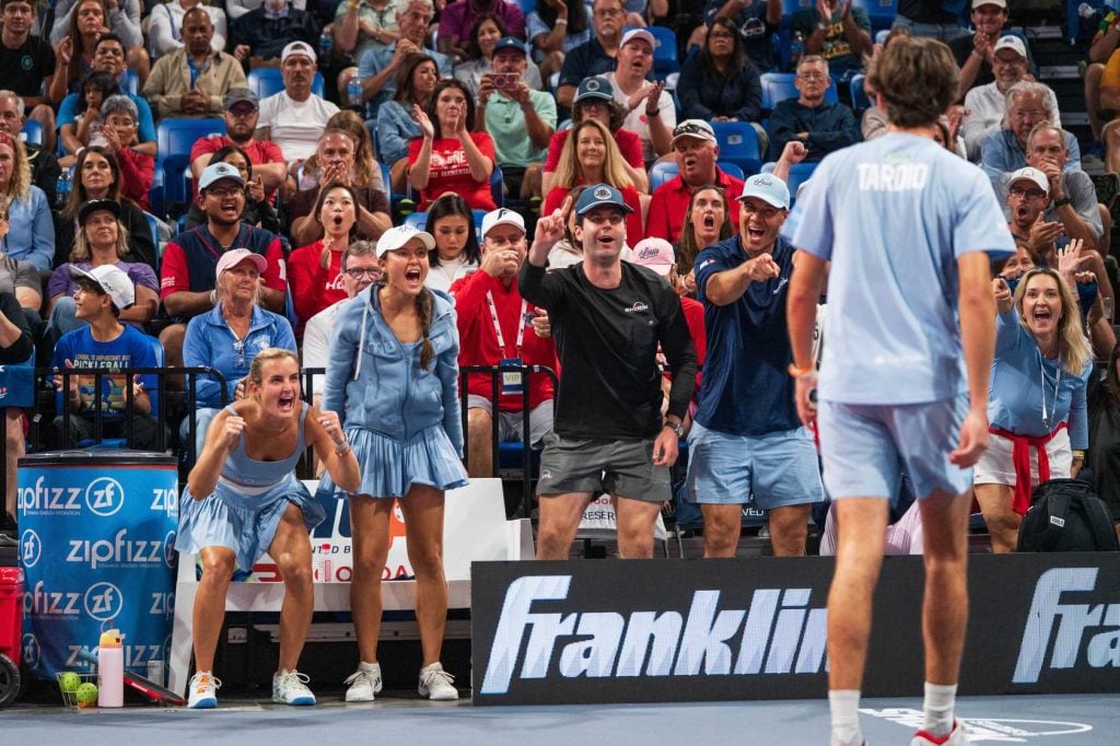 Excited pickleball fans cheering at Major League Pickleball match.