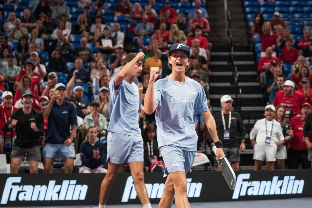 Two female pickleball players celebrating on court during a Major League Pickleball match.