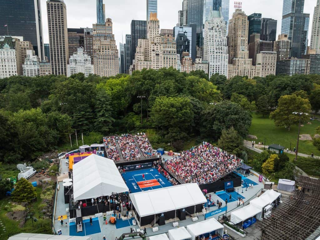 Aerial view of Major League Pickleball tournament in Central Park with city skyline.
