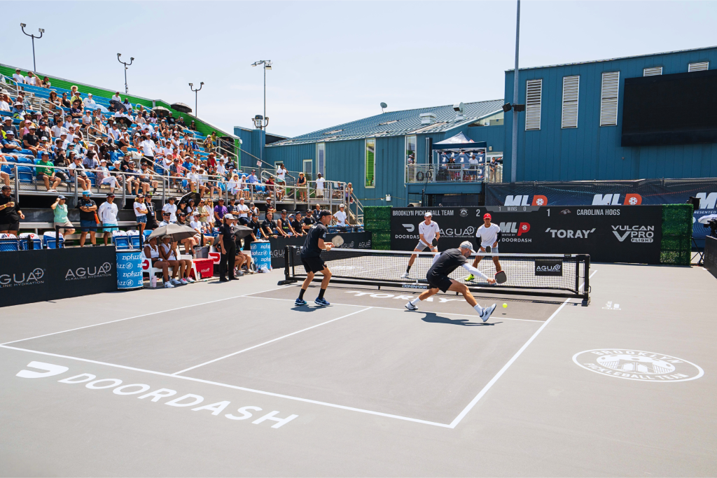 Exciting pickleball match at Major League Pickleball tournament with players and crowd.