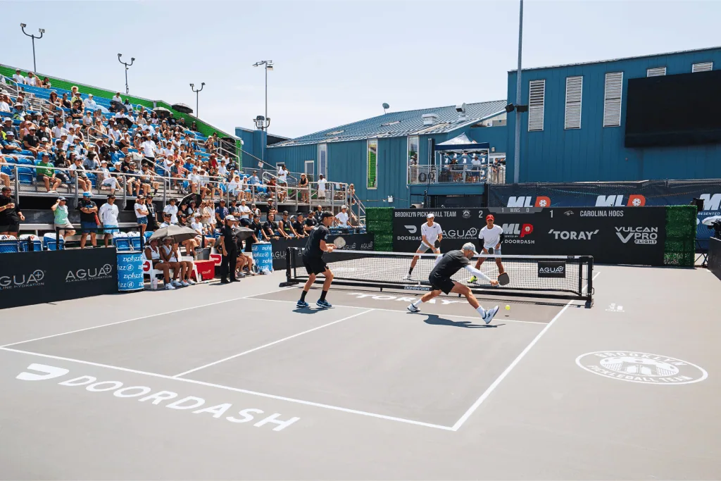 Exciting pickleball match at Major League Pickleball tournament with players and crowd.