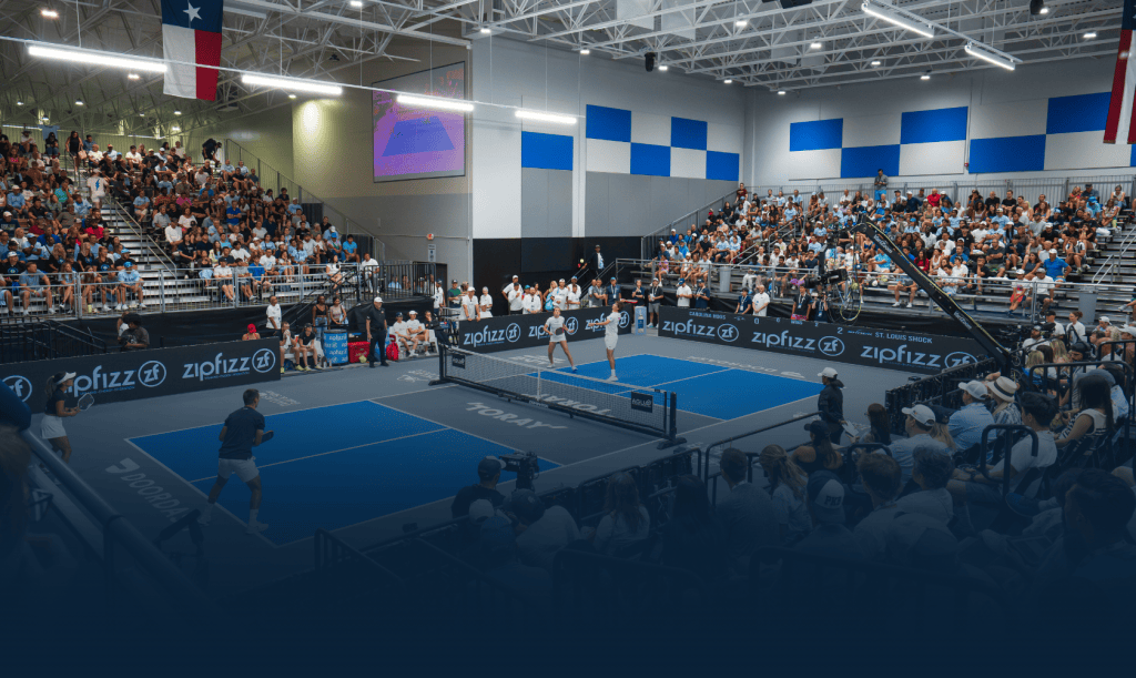 Professional pickleball match at Major League Pickleball event with players and audience.
